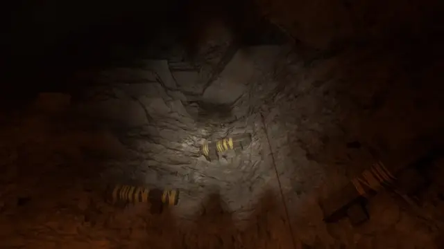 Yellow-marked grab ledges climb a cavern wall above the lower path.