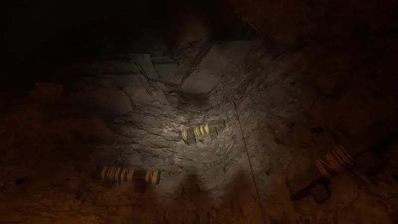 Yellow-marked grab ledges climb a cavern wall above the lower path.