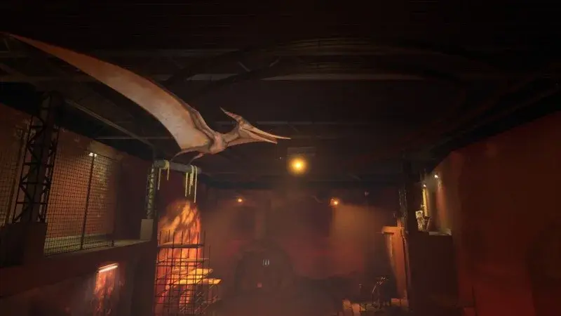 Pterosaur exhibit model hanging from overhead machinery above a gap