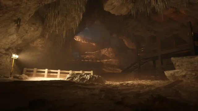 Cavern worksite with wooden walkways, stairs, and portable lights